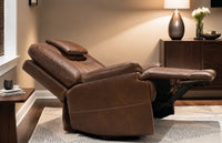 Brown leather recliner chair in a living room setting with a lamp and flowers on a side table.